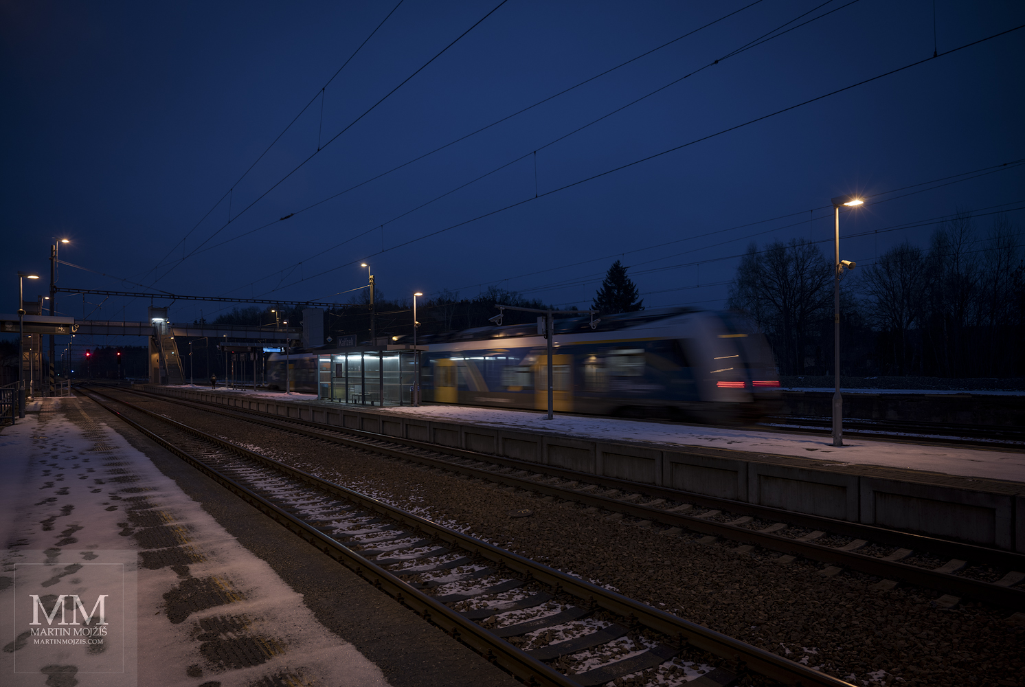 Noční osobní vlak odjíždí směrem k Berounu.