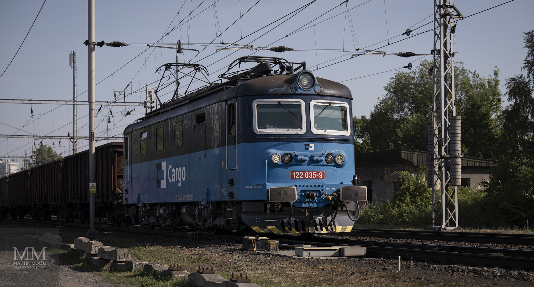 Lokomotiva 122 035-9 ČD Cargo v čele nákladního vlaku ve směru Kralupy nad Vltavou.