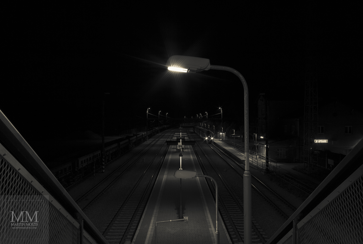 A lamp by the overpass staircase. Karizek railway station at night.
