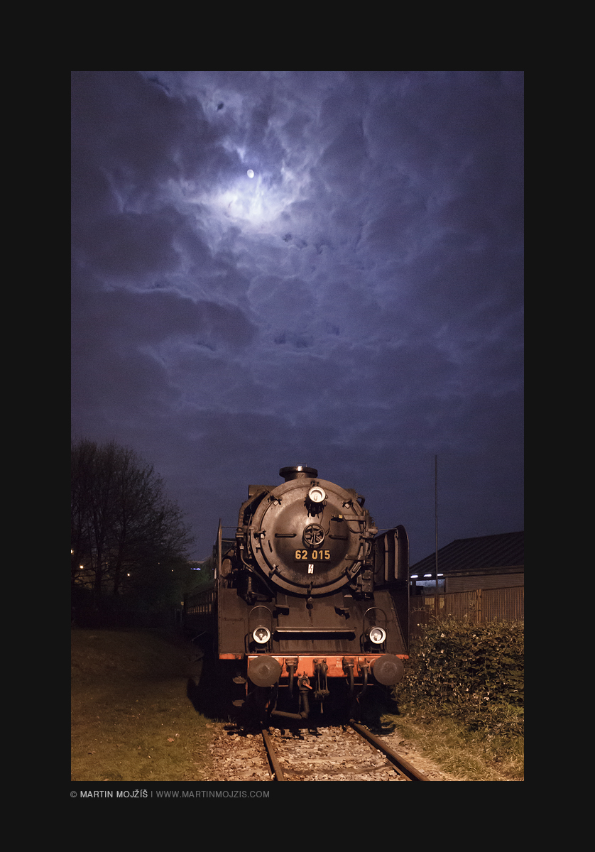 Steam locomotive below a night sky with Moon.