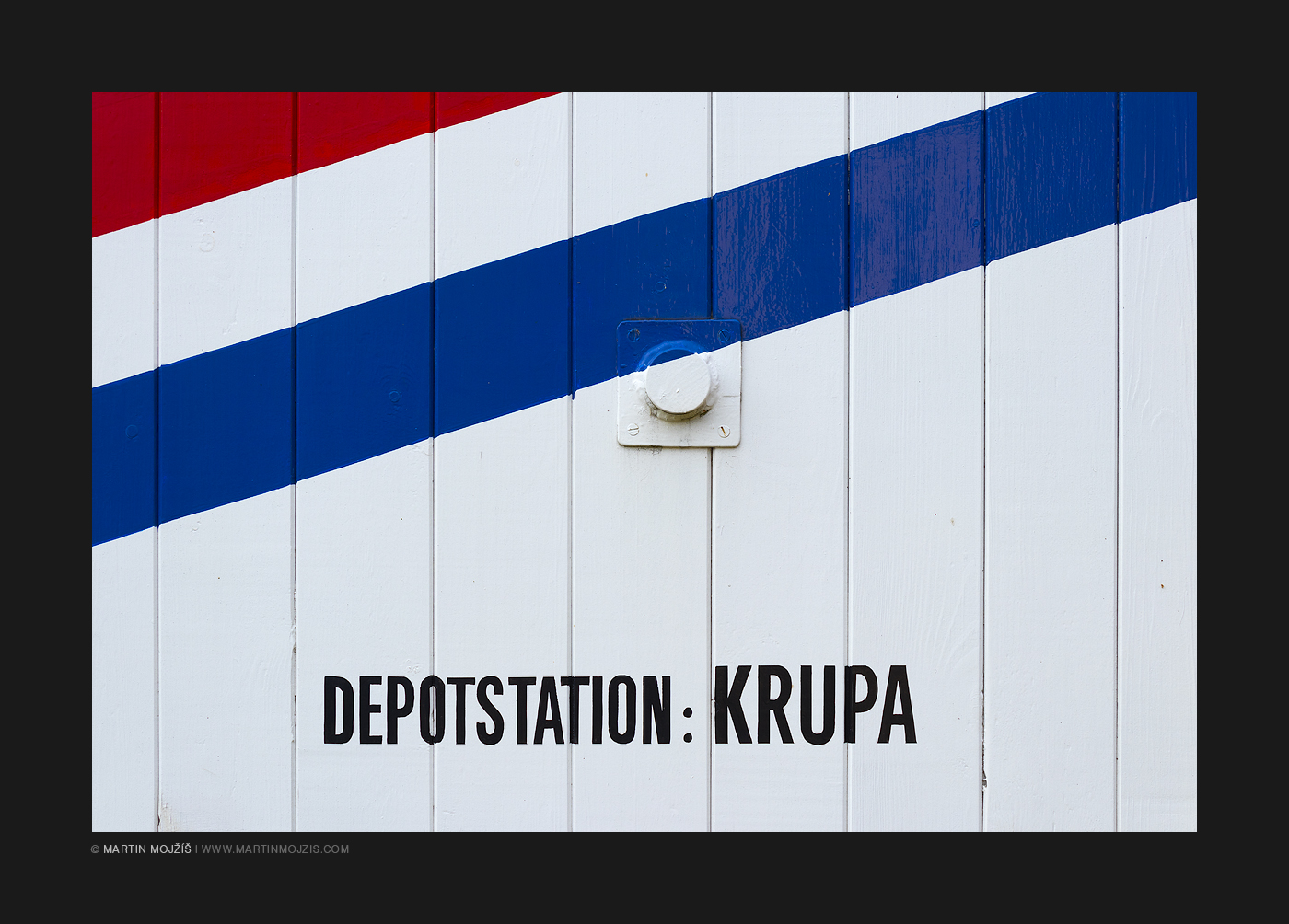 White painted wooden wagon wall, red and blue stripe. Lettering Depotstation: Krupa. Railway muzeum in Luzna near Rakovnik.