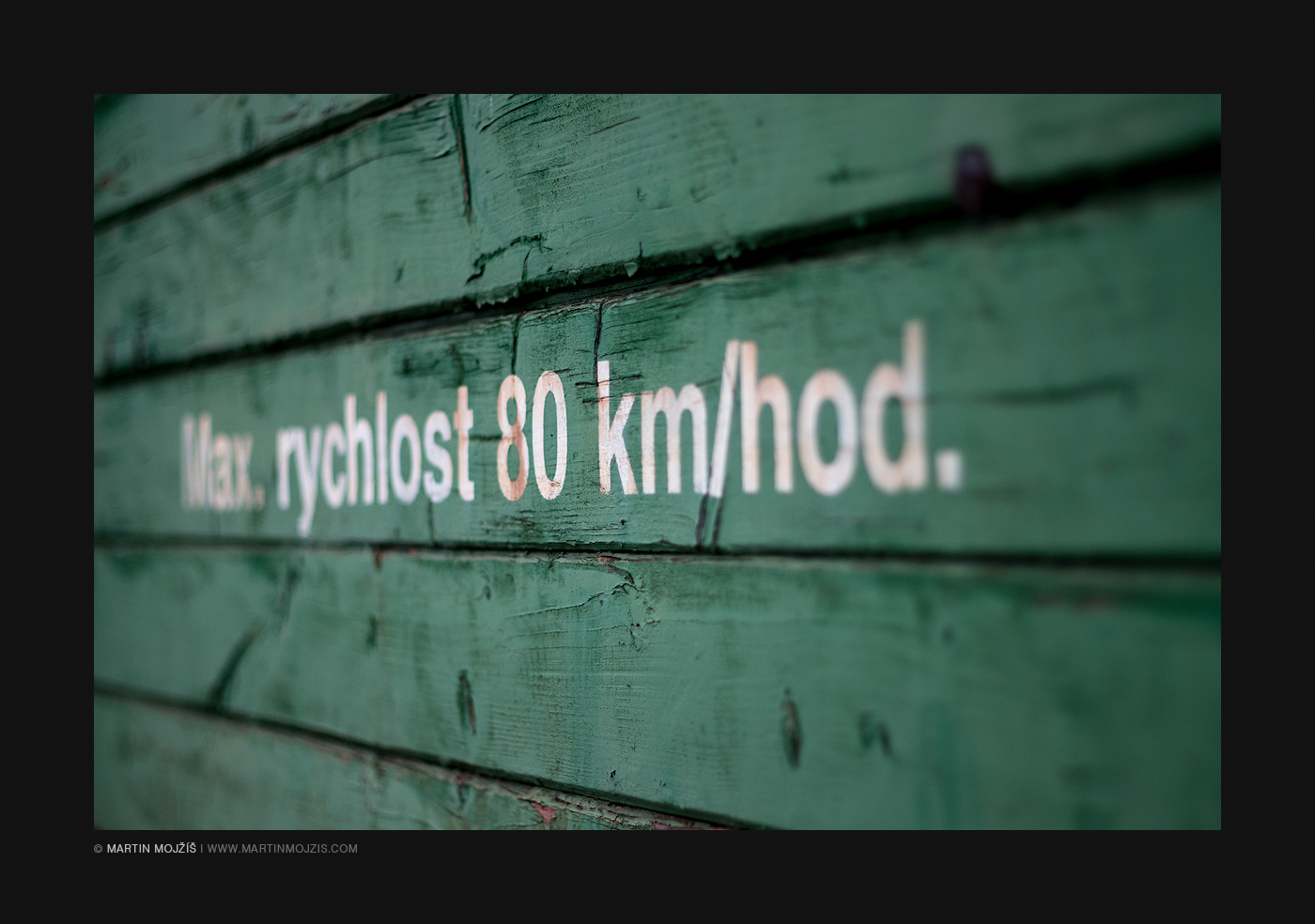 Nápis na zeleně natřené dřevěné stěně železničního vagonu, udávající nejvyšší povolenou rychlost 80 km/hod. Železniční muzeum v Lužné u Rakovníka.
