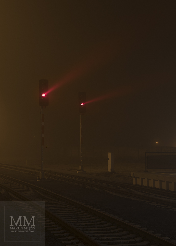 Red rays of light in a foggy, frosty night. Railway station Ceska Lipa.