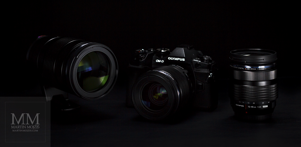 Three photographic lenses and the Olympus OM-D E-M1 Mark II photographic camera.