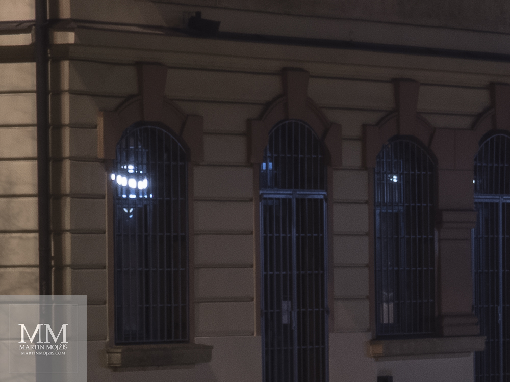 Nádraží Roztoky u Prahy v noci, pohled na okna chráněná mřížemi. Fotografie vytvořená fotoaparátem Olympus OM-D E-M1 Mark II.