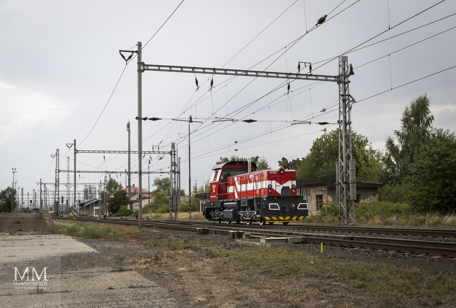 Červeno-bílá diesel-elektrická posunovací lokomotiva 724 708-3.