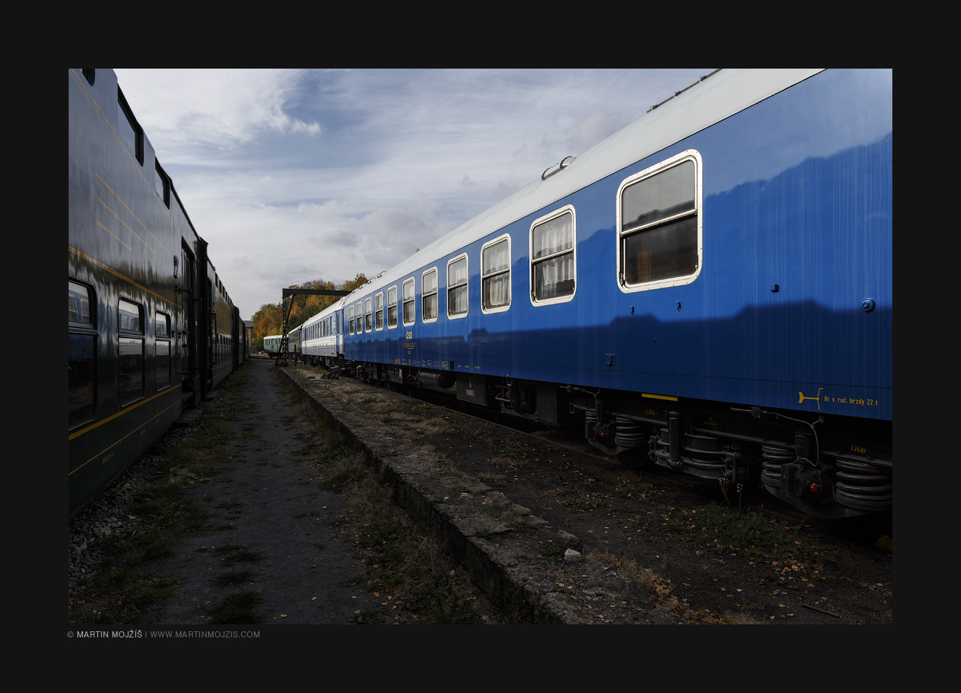 Modrý osobní železniční vagon.