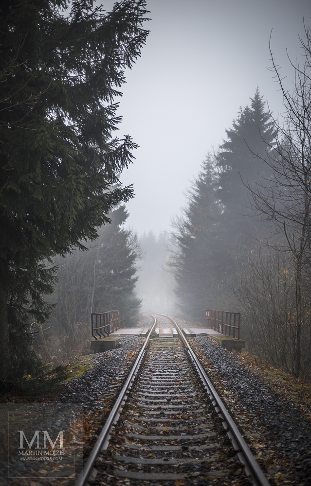 Velkoformátová umělecká fotografie horské železniční tratě v mlhavém dni. Martin Mojžíš.