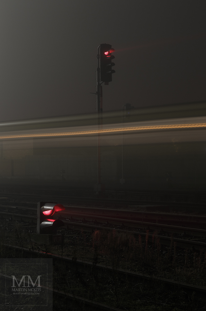 Velkoformátová umělecká fotografie železničních návěstidel v noci u projíždějícího vlaku. Martin Mojžíš.