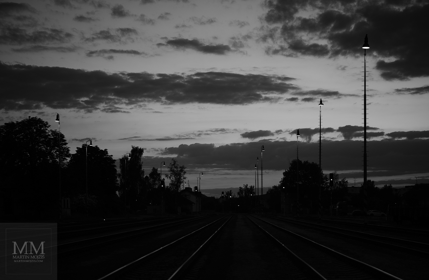 Večerní železniční nádraží. Umělecká černobílá fotografie s názvem DOTEKY VEČERNÍHO SVĚTLA. Fotograf Martin Mojžíš.