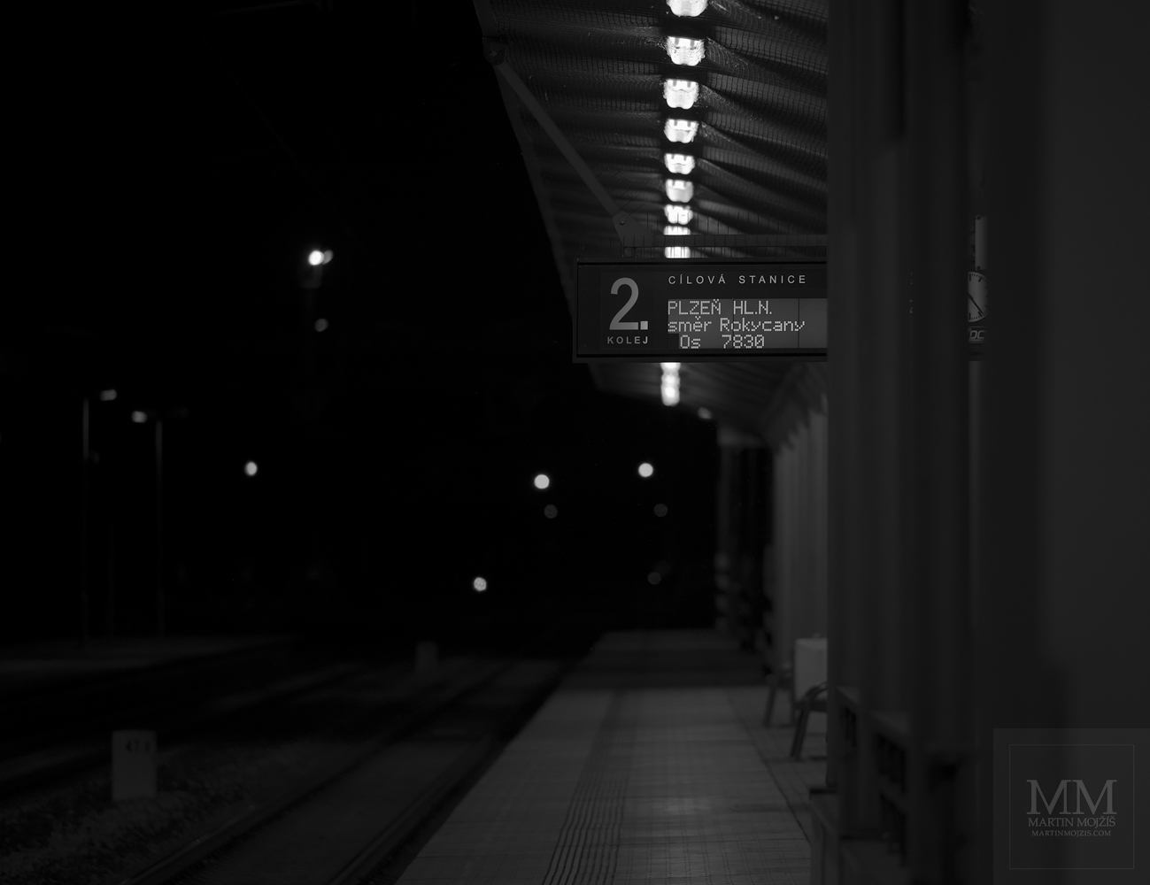 Železniční nádraží v noci. Umělecká černobílá fotografie s názvem DO PLZNĚ. Fotograf Martin Mojžíš.