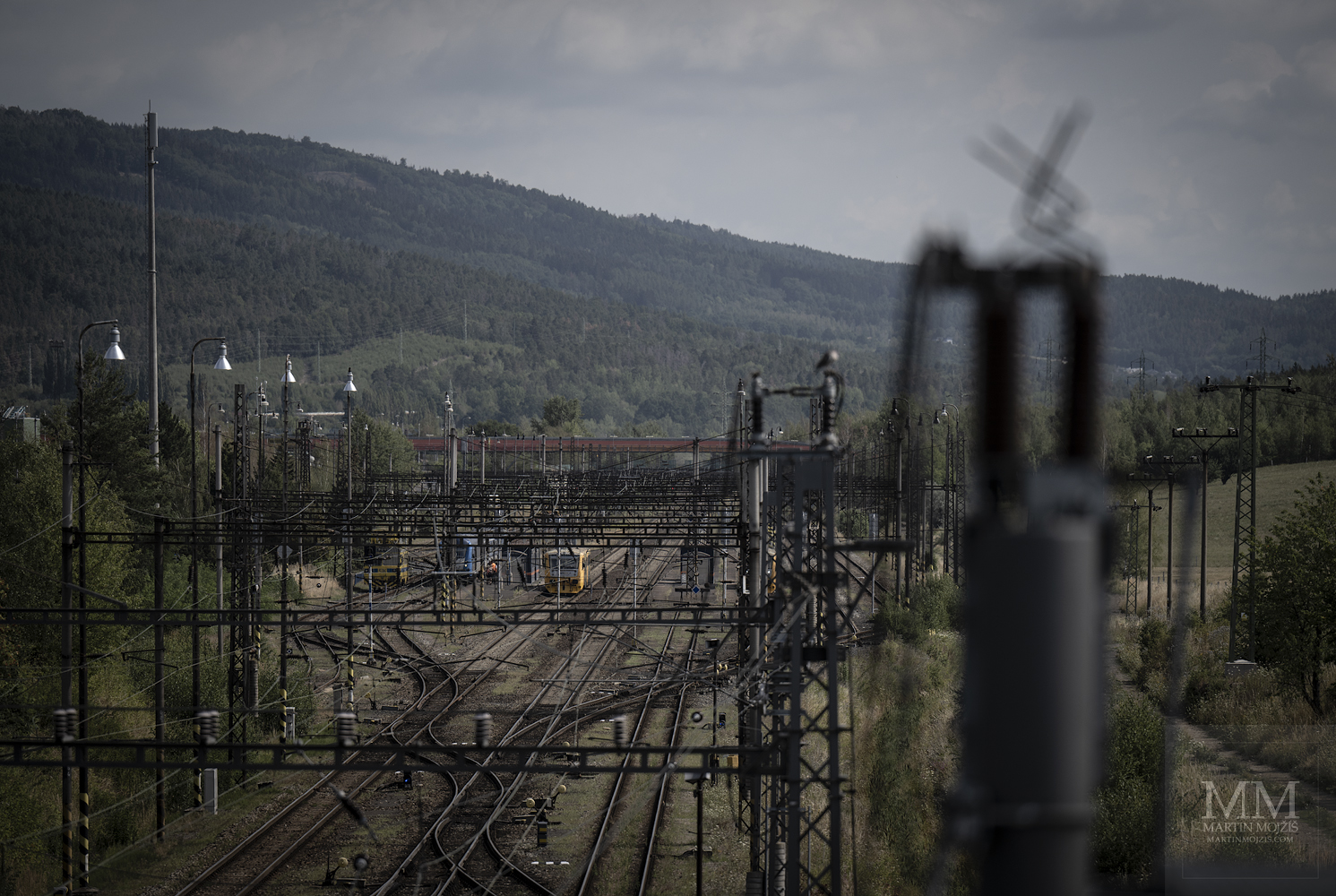 Železniční trolejové vedení nad tratěmi po horami. Umělecká fotografie s názvem ENERGIE POD HORAMI. Fotograf Martin Mojžíš.