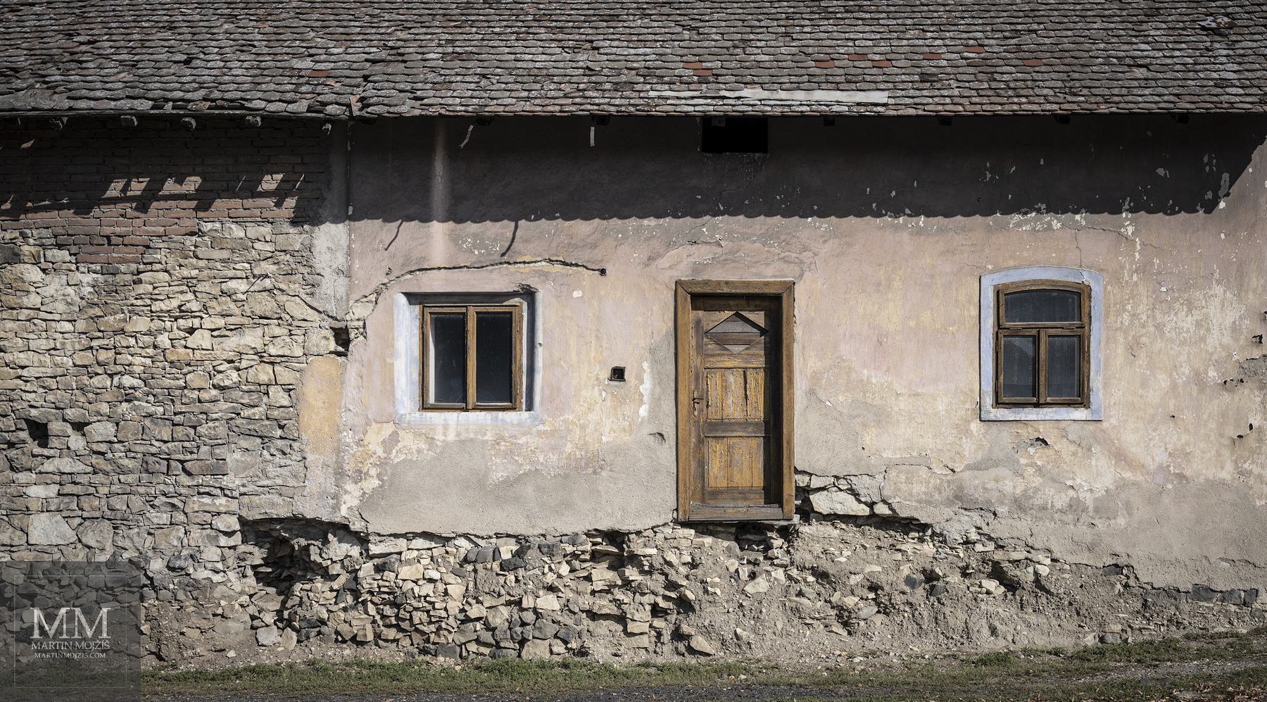An old house with a door, to which there are no stairs. Fine art photograph IT IS NOT EASY TO ENTER, photographed by Martin Mojzis.