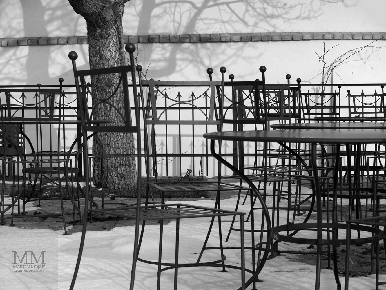 Metal chairs and tables on the terrace. Photograph with the title BRAWL.