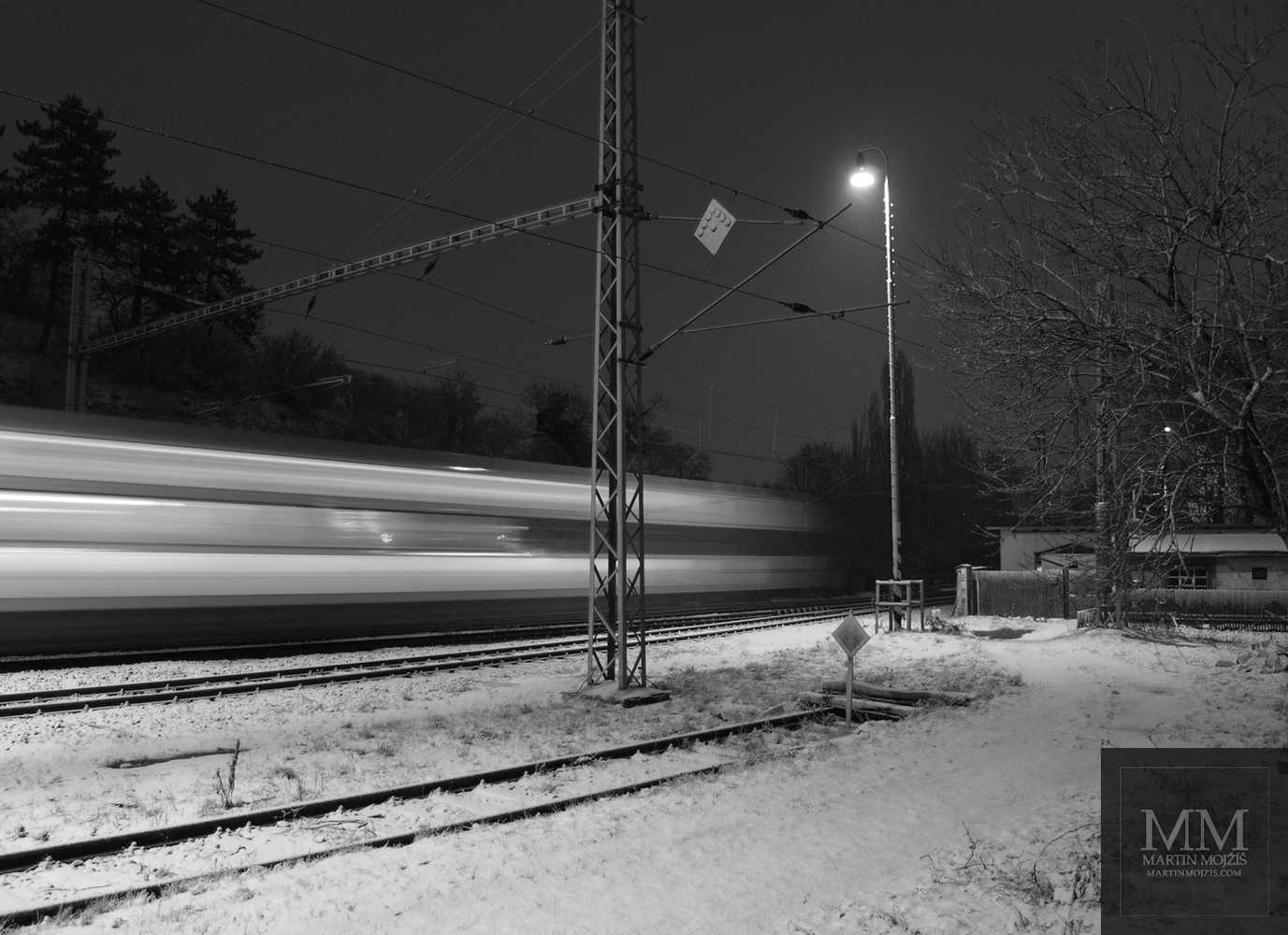 Fast passing train, winter snowy railway station. Photograph with the title NIGHT EXPRESS.