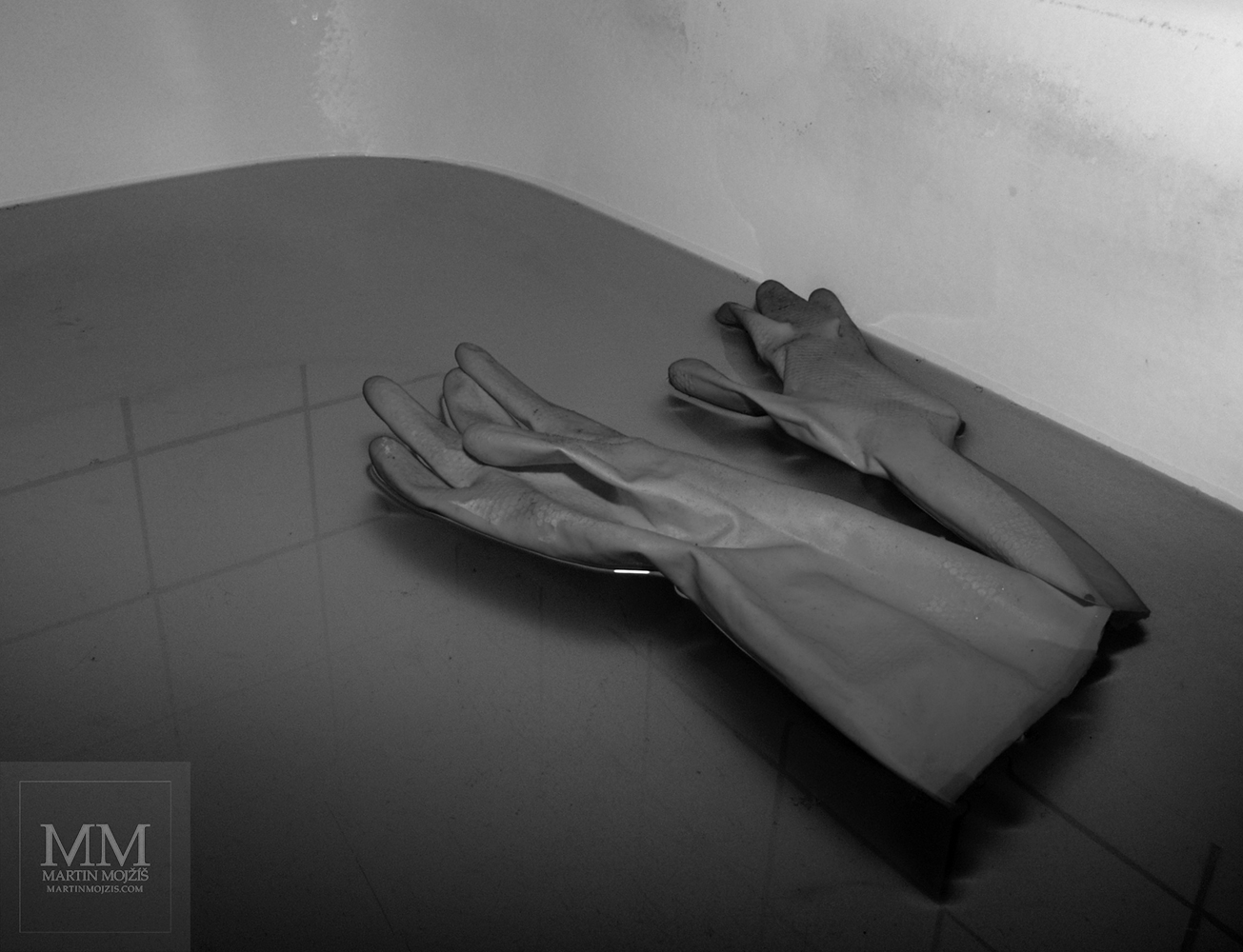 Rubber gloves floating on the water surface in the tub. Photograph with the title FLOATING.