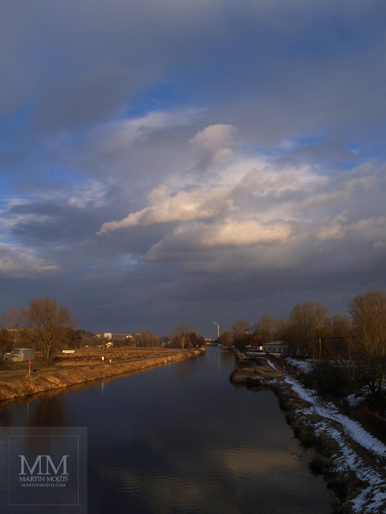 River, clouds and golden light. Photograph with the title SILENCE.