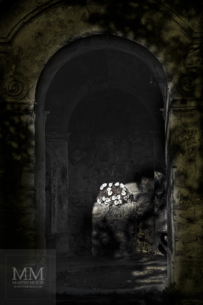 Kamenná kaple, uprostřed osvětlená kytice kal. Umělecká fotografie Martina Mojžíše s názvem KALY.