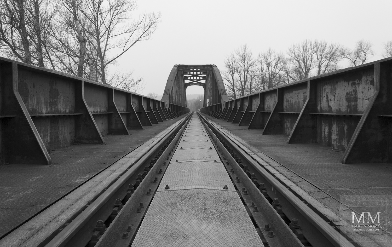 Mohutné zábradlí ocelového železničního mostu. Umělecká černobílá fotografie Martina Mojžíše s názvem TICHEM K VEČERU.