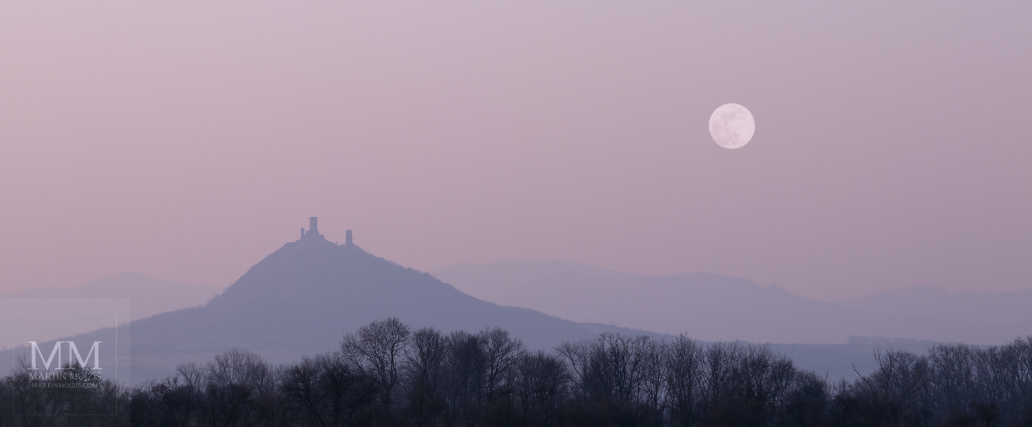 Panoramatická fotografie podvečerní krajiny s Měsícem.