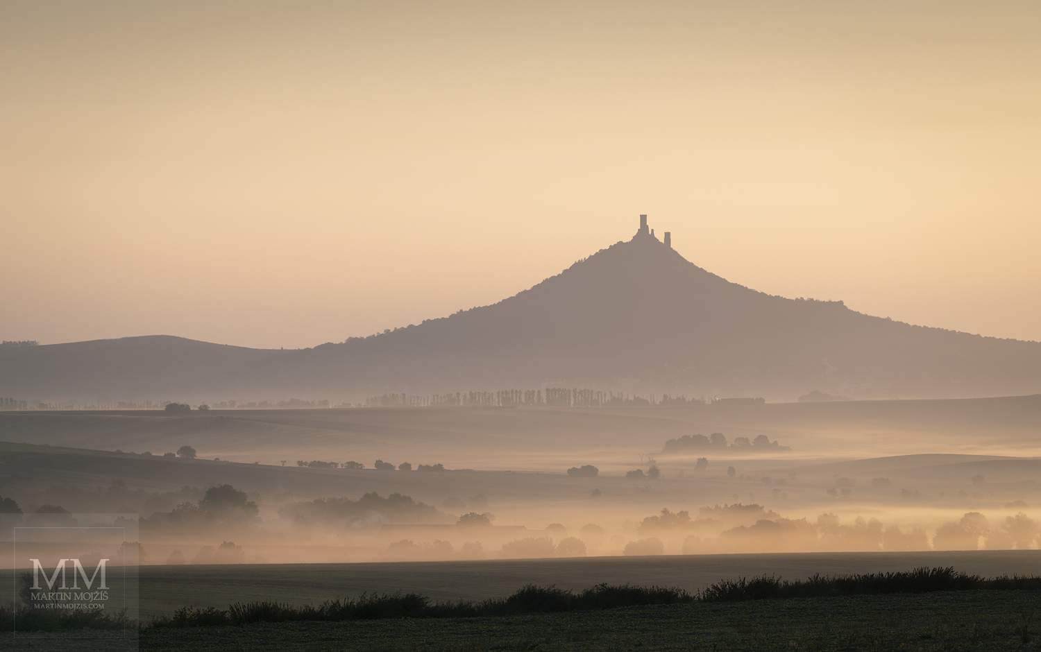 Landscape with morning mists, Hazmburk hill (Klapy) in the background. Fine Art large format photograph Light of a new day. Photographer Martin Mojzis.