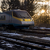 A Pendolino high speed train on a railway in a sunny winter evening.