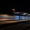 Train passing Horovice railway station at night.
