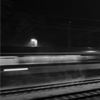 Noční vlak jedoucí po osvětlené zasněžené trati.