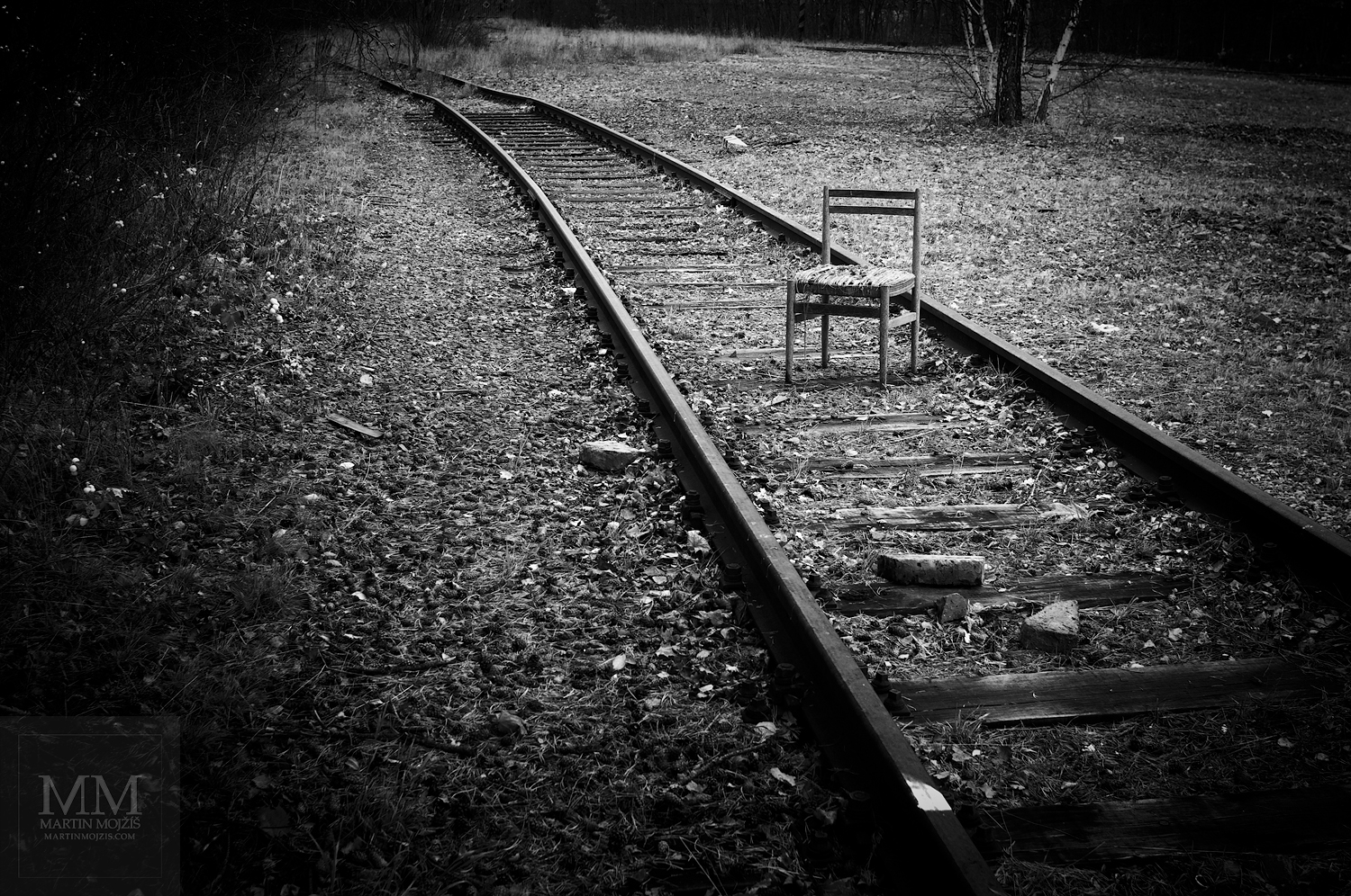 Židle na koleji vlečky. Umělecká černobílá fotografie Martina Mojžíše s názvem VÍTEJTE V MÉM DOMĚ III.